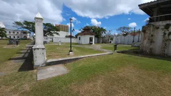 A park with a white building and grass