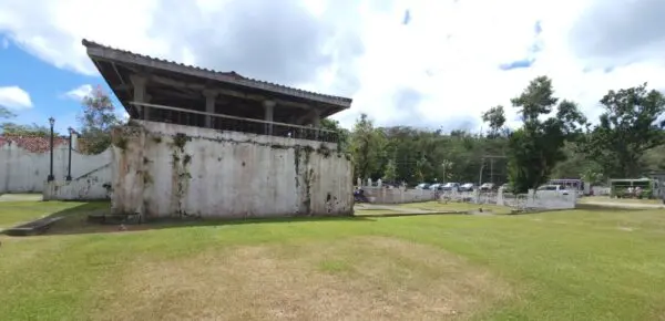 A large concrete wall in the middle of a field.