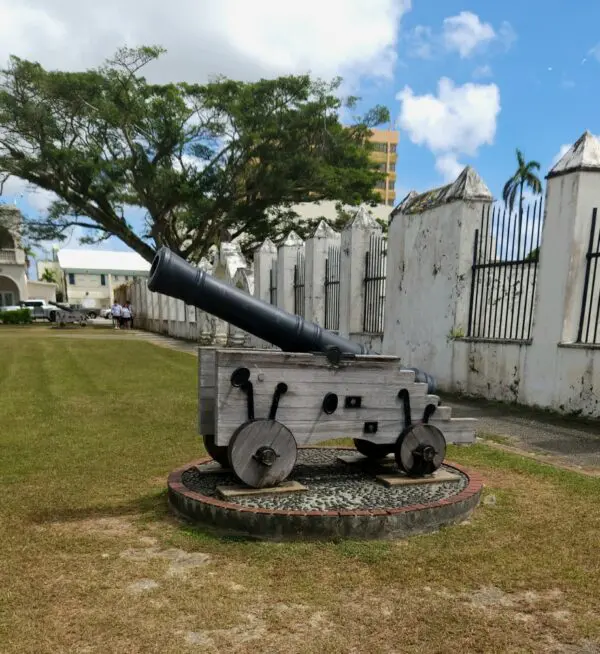 A cannon is on display in front of the gate.