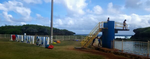 A man is climbing up the stairs to an outdoor gym.