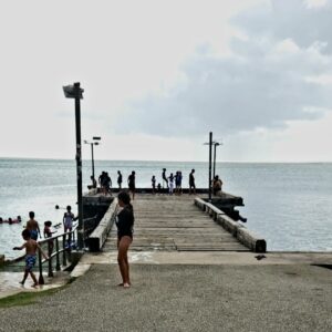 A group of people standing on the edge of a pier.