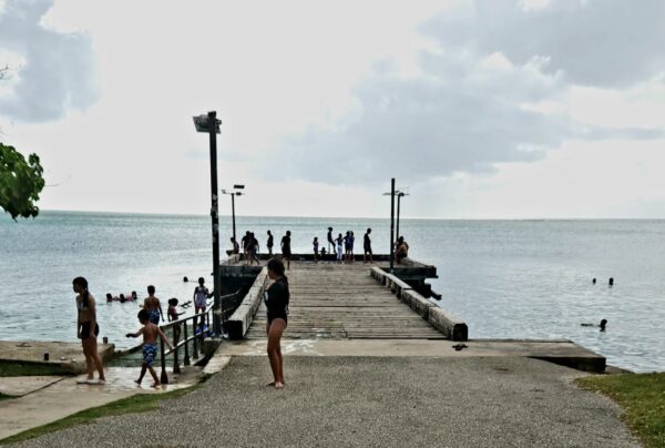 A group of people standing on the edge of a pier.